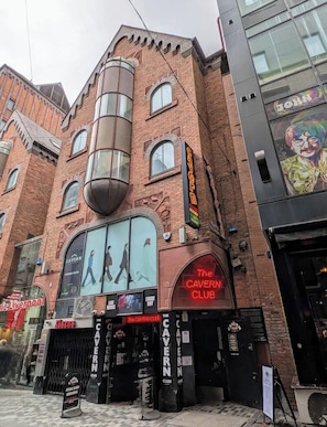 A brick building with a large sign for 'The Cavern Club' and a poster of The Beatles. - City Comfort Retreat in Liverpool (Liverpool)