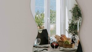 A dining table with a view of the outdoors, a plant, and a fruit bowl. - Villa Oleander: Pool & Rooftop Cinema (Splitska)