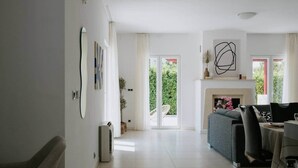 A spacious living area with a fireplace, a sofa, and a dining table. - Villa Melograno: Pool & Rooftop Cinema (Splitska)