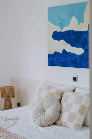 A bedroom with a bed, pillows, a wall-mounted artwork, and a bedside lamp. - Villa Melograno: Pool & Rooftop Cinema (Splitska)