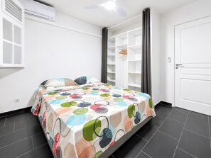Une chambre à coucher avec un lit, une armoire et une porte.