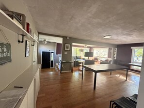 A spacious living area with a dining table, a sofa, and a TV. There is a staircase leading to another level. - Sleeps 16! - Breaking Away to Bloomington (Bloomington)