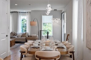 A dining area with a round table set for six, surrounded by six chairs. - Songbird A. Sleeps 12 . Comp Broadway Shuttle . Rooftop Jacuzzi (Nashville)