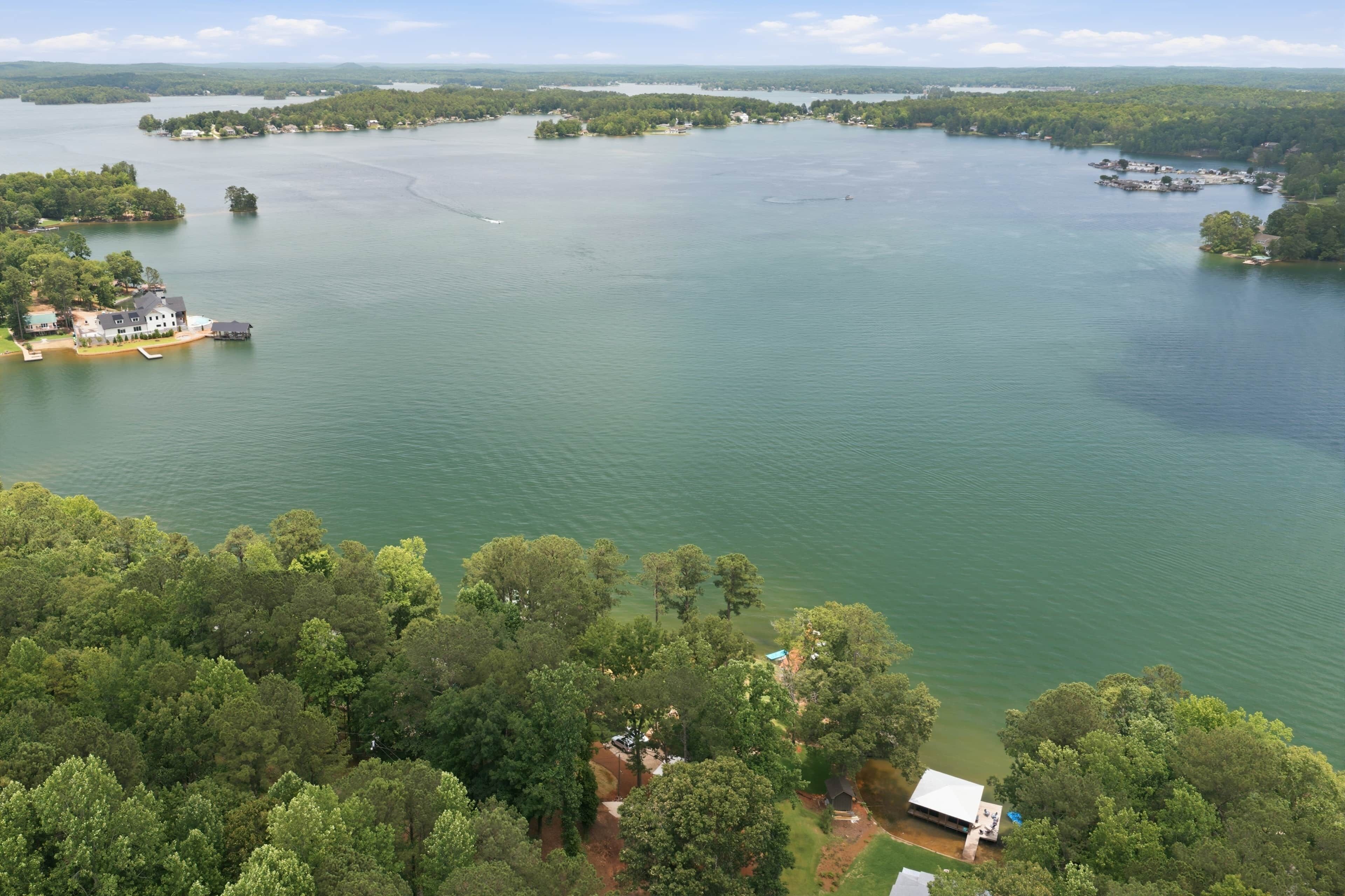 A large body of water with several islands, surrounded by dense forest.