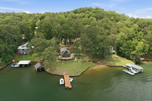 A lakeside property with a house, dock, and boat. - Brighter Days-Lake Martin Retreat (Tallapoosa County)