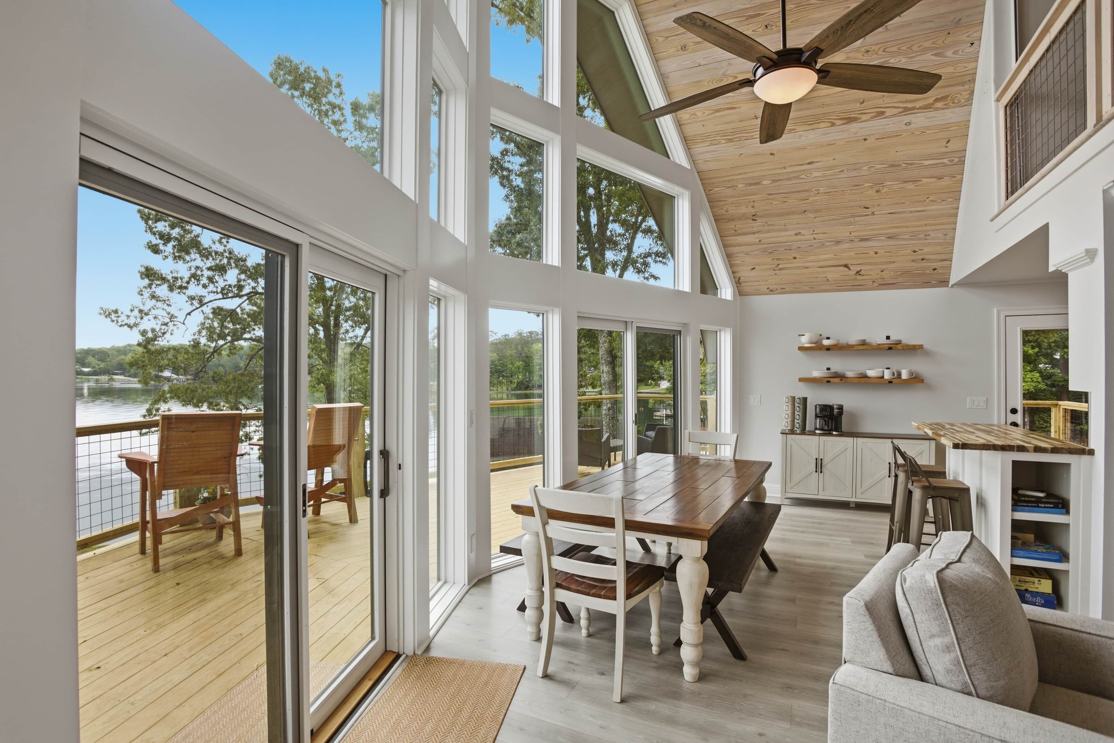 A modern interior with a wooden deck, a dining area, and a kitchen.