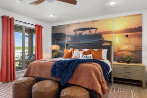 Une chambre à coucher avec un grand lit, une table de chevet, une horloge murale et une fenêtre avec des rideaux.