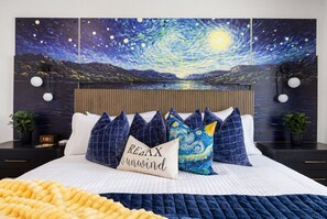 A bedroom with a bed, pillows, a nightstand, a clock, and a wall painting. - Wake & Lake Lodge, Private Dock, Deep Water & Incredible Lake Views (Graford)