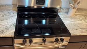 Eine Küche mit Edelstahlherd, Backofen und Mikrowelle.