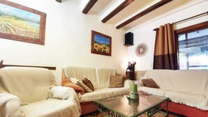 Ein Wohnzimmer mit einer Couch, einem Glastisch und einem Gemälde an der Wand.