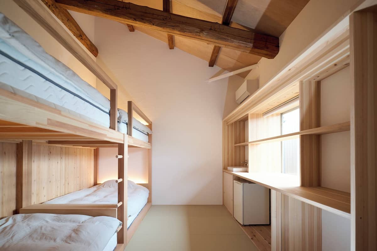 Habitación compacta con literas, kitchenette pequeño y ventana que proporciona luz natural.