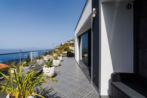 Ein modernes Gebäude mit Balkon und Blick auf die Küste.