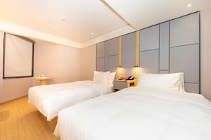 A hotel room with two beds, a bedside table, a nightstand, a wall-mounted phone, and a large window. - Ji Hotel (Nanjing)