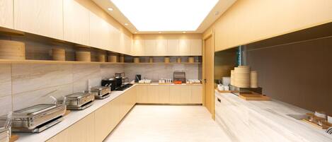 A modern kitchen with wooden cabinets, a marble countertop, and various kitchen appliances.