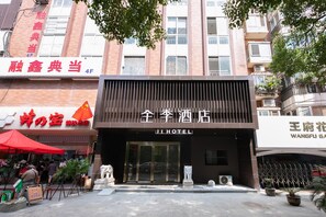 A hotel entrance with a modern facade, a large glass door, and a sign indicating the name 'JI HOTEL'. - Ji Hotel (Nanjing)