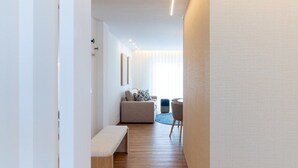A modern interior with a wooden floor, a bench, a sofa, and a dining area. - GuestReady - Charming retreat in Fátima (Fátima)