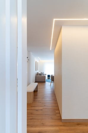 A modern interior with a wooden floor, a bench, a sofa, and a dining area. - GuestReady - Charming retreat in Fátima (Fátima)