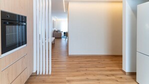 A modern kitchen with a built-in oven, wooden cabinetry, and a white countertop. - GuestReady - Charming retreat in Fátima (Fátima)