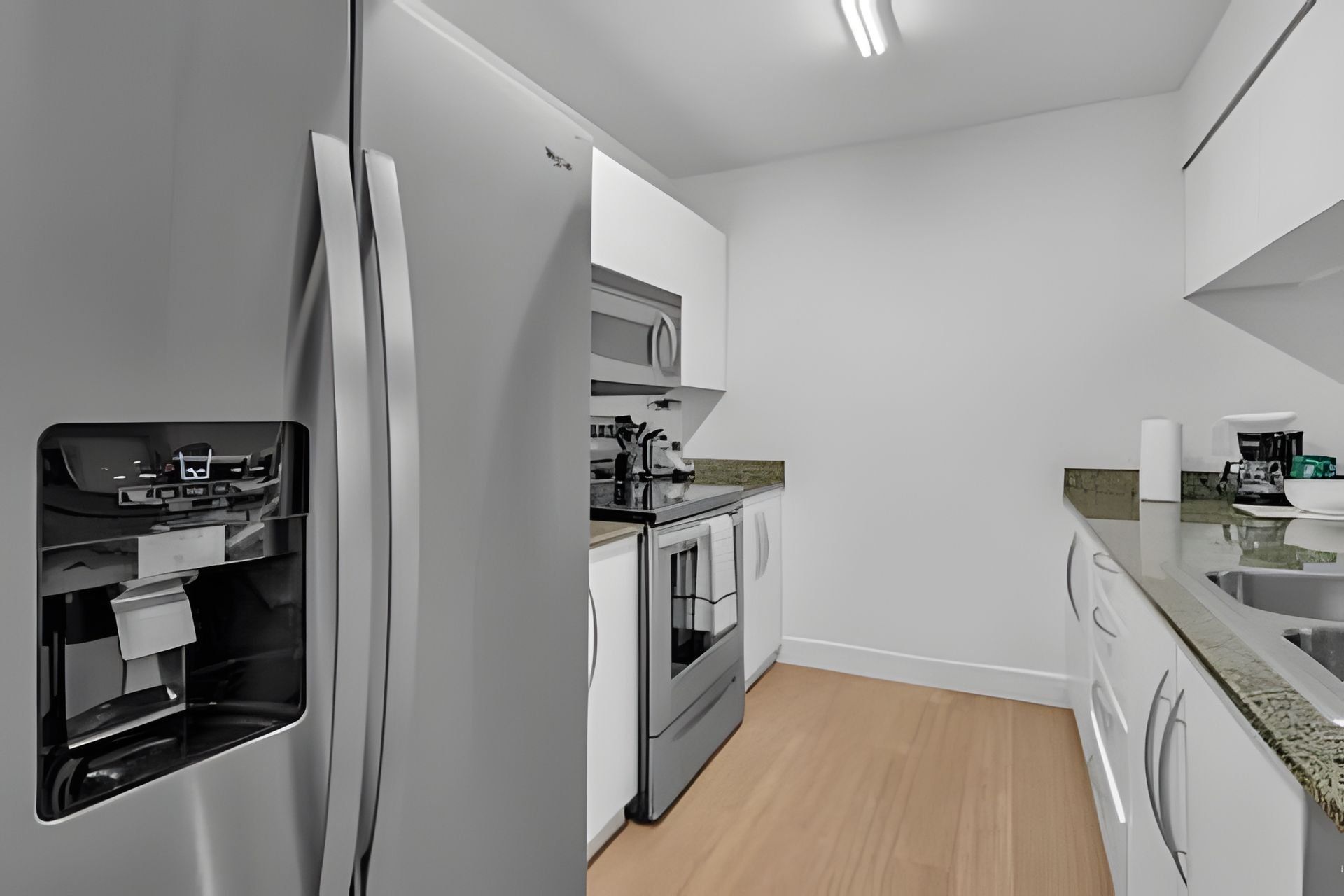 A modern kitchen with stainless steel appliances, a microwave, oven, and a dishwasher.
