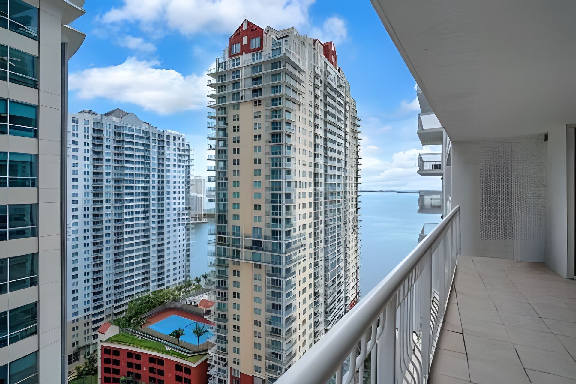 Ein Hochhaus mit mehreren Balkonen, einem Pool und Blick auf das Meer.