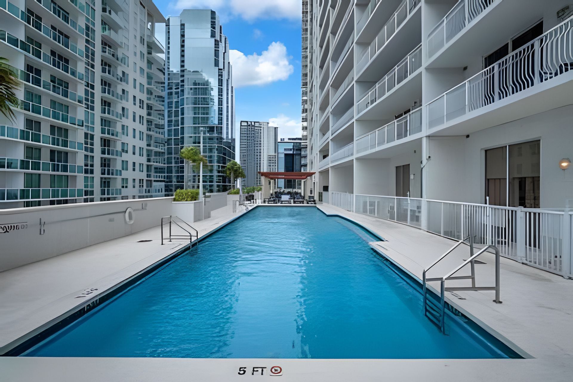 Piscina em edifício moderno com vários andares e varandas.