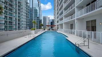 Piscina em edifício moderno com vários andares e varandas.