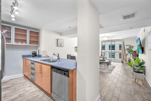 A modern kitchen with a dishwasher, a built-in oven, and a sink. - The Club (Miami)
