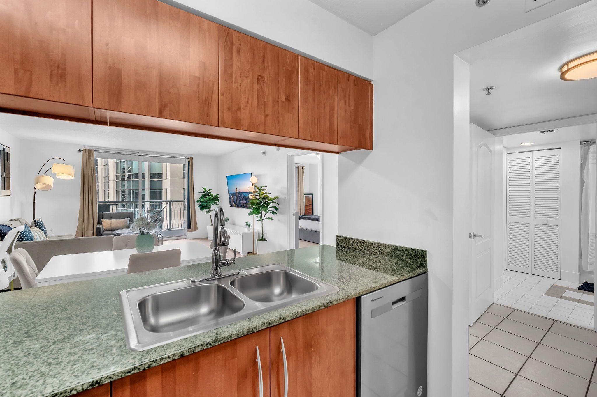 A modern kitchen with wooden cabinets, a double sink, and a dishwasher.