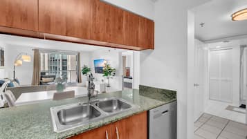 A modern kitchen with wooden cabinets, a double sink, and a dishwasher.
