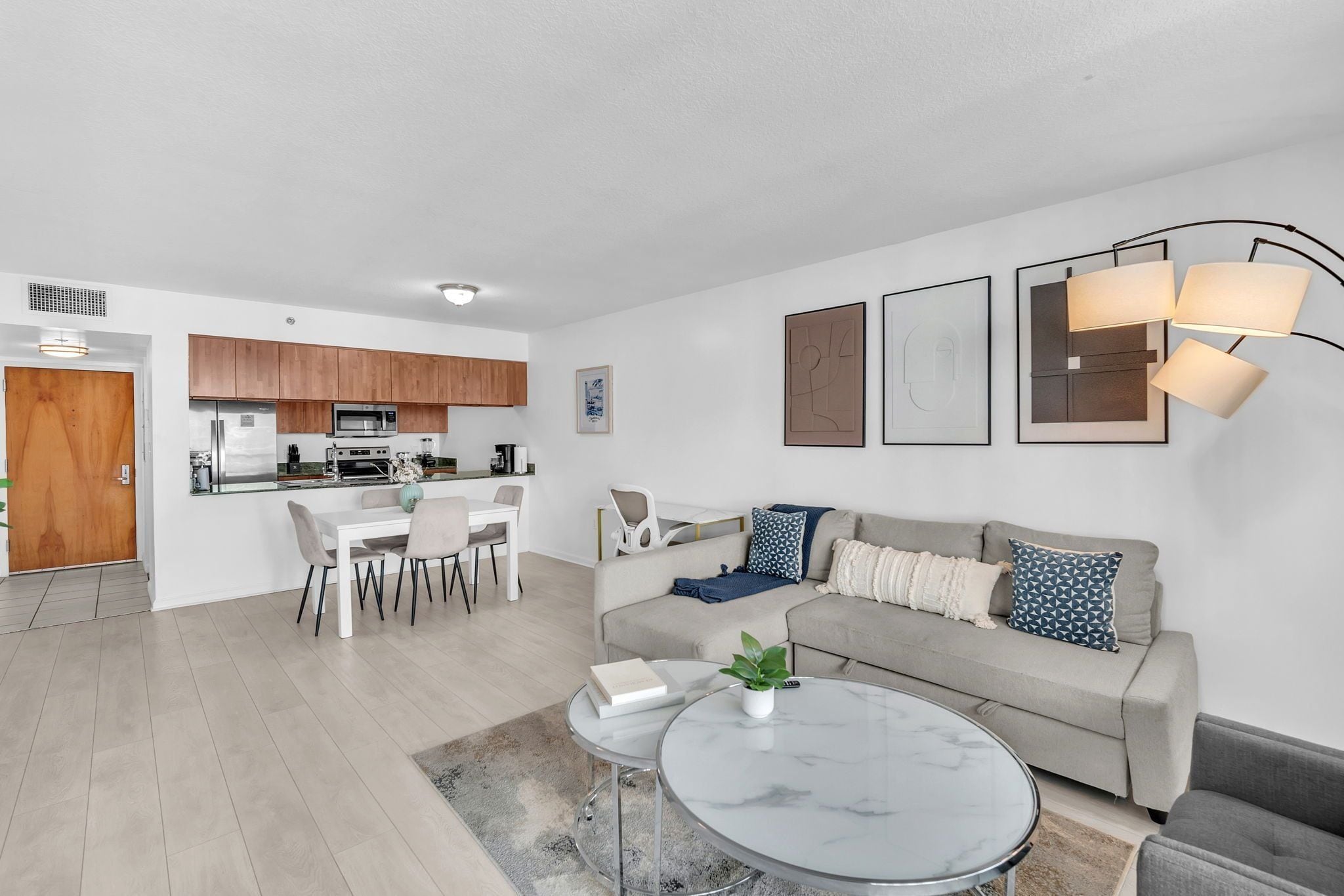 A modern living room with a sofa, coffee table, and dining area.