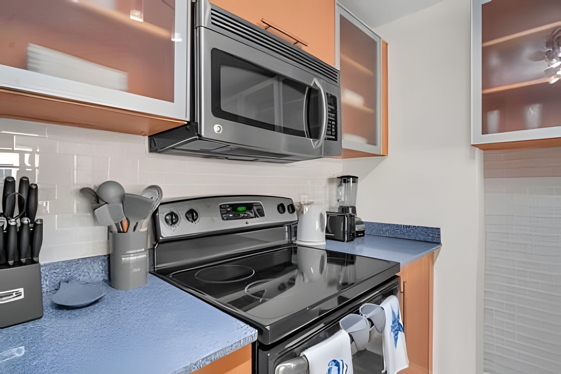 A modern kitchen with a stainless steel microwave, oven, and coffee maker.