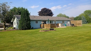 A residential house with a front yard, a mailbox, and a wooden fence.
