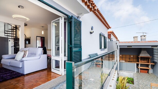 Een modern appartement met een balkon, een eethoek en een keuken met buitenbarbecue.
