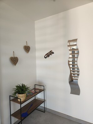 A minimalist room with a wooden console table, a potted plant, and a unique wall art piece.