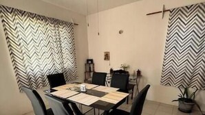 A dining area with a table, chairs, a ceiling fan, and curtains. - The House in the Southeast / Covered Parking / Family Home (Chetumal)