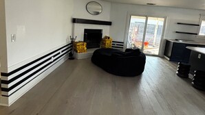 A spacious living area with a fireplace, black and white striped baseboard, and a black bean bag. - Peaceful four bedroom home (Ripon)
