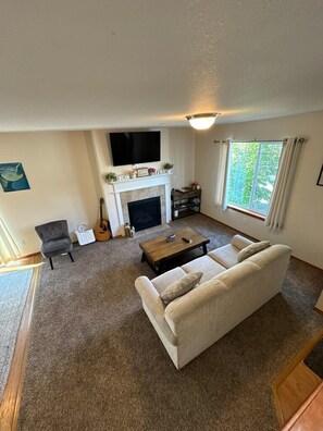 A living room with a fireplace, sofa, and a television.