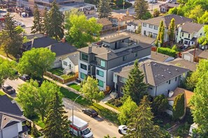 Un moderno edificio residenziale a più piani con tetto piatto, ampie finestre e un garage visibile.