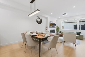 Un comedor moderno con una mesa de madera dispuesta para cuatro personas, rodeada de sillas.