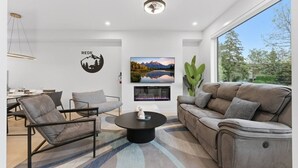 A modern living room with a sofa, chairs, a coffee table, and a fireplace. - 4 Ensuites | Private Rooftop | Bar Lounge | Slps 8 (Calgary)