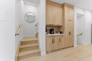 Una cucina moderna con mobili in legno, un piano di lavoro e una macchina da caffè.