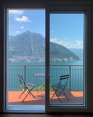 A balcony with two chairs and a table, overlooking a lake and mountains. - Villa top view Lake Como (Faggeto Lario)