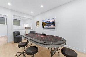 A conference room with a round table, four chairs, a lamp, and two framed pictures on the wall. - Spacious Calgary Home | Rooftop Views | Sleeps 10 (Calgary)