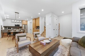 A modern apartment with a kitchen, dining area, and living room. - Spacious Calgary Home | Rooftop Views | Sleeps 10 (Calgary)