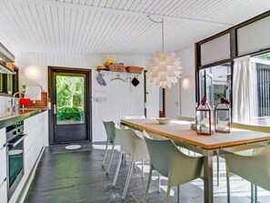 A modern kitchen with a wooden countertop, white cabinets, and a black door. - 4 Star Holiday Home in Dronningmolle (Dronningmolle)