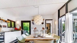 Una cucina moderna con zona pranzo, ampie finestre e vista sul verde.