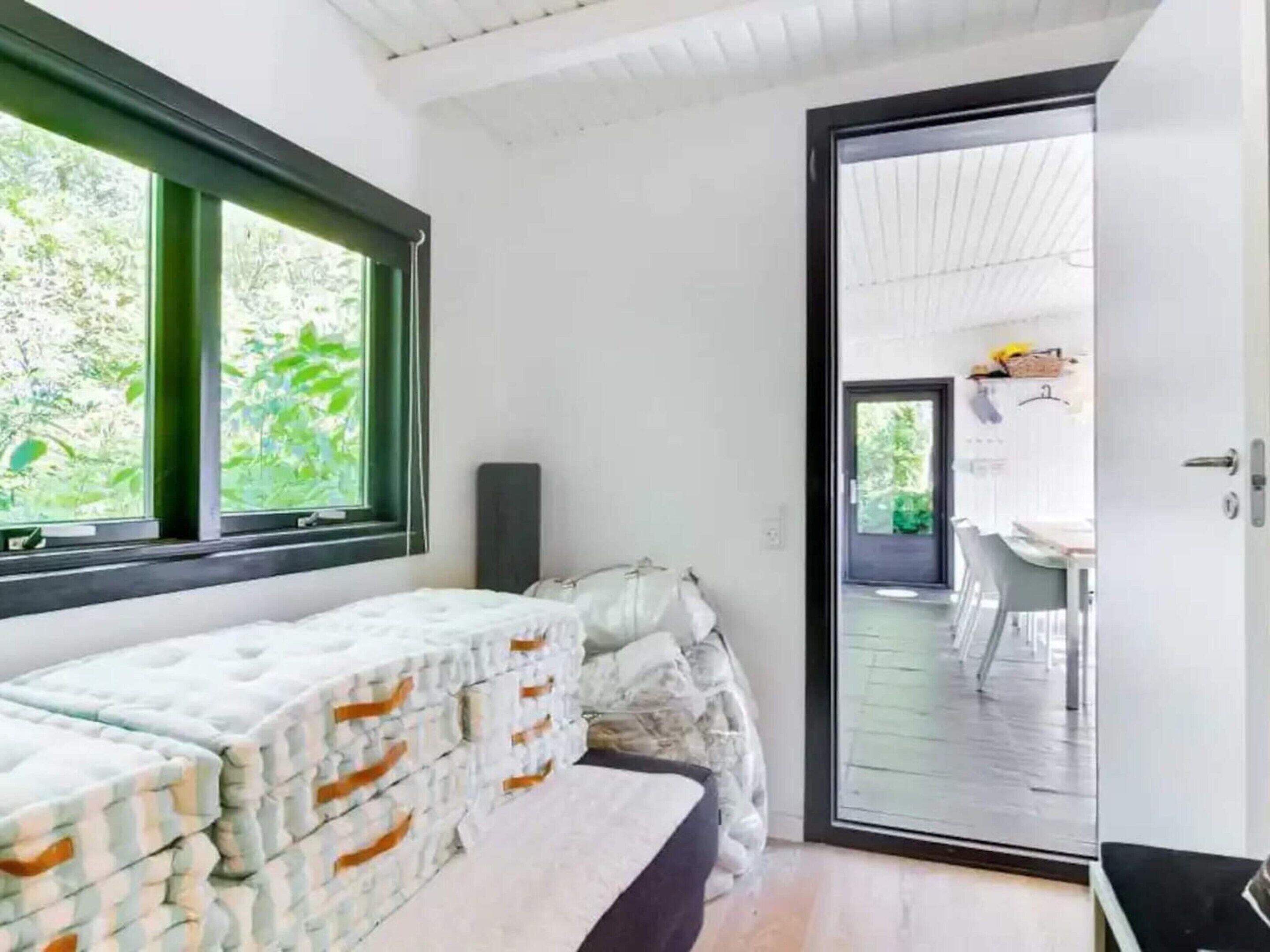 A room with a bed, a window, and a door leading to a balcony.