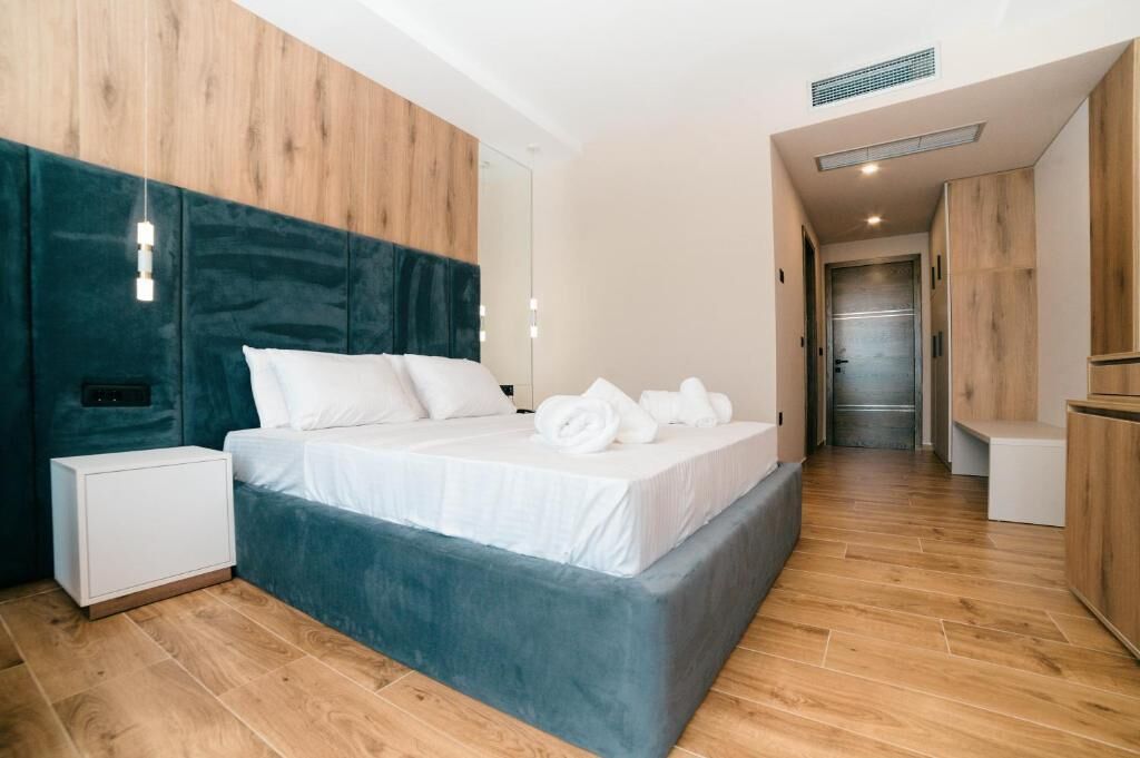 Quarto moderno com uma cama grande, uma mesa de cabeceira e um guarda-roupa.
