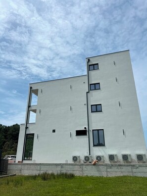 A modern building with a flat facade, multiple windows, and air conditioning units. - Hotel Velmare (Ulcinj)