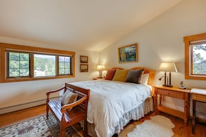 Un dormitorio con una cama grande, muebles de madera y vistas a través de las ventanas.